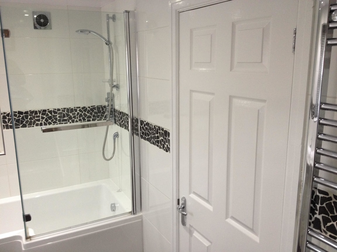 Freshly fitted bathroom with bath, shower screen and heated towel rail in Archway